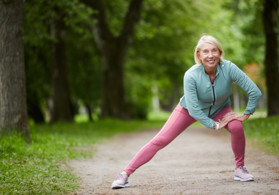 Woman outside stretching and smiling